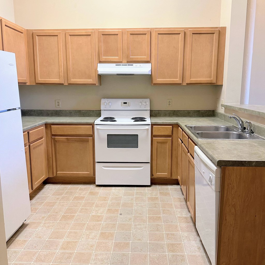 a kitchen with wooden cabinets and a stove and a sink