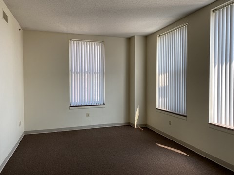 an empty living room with two windows