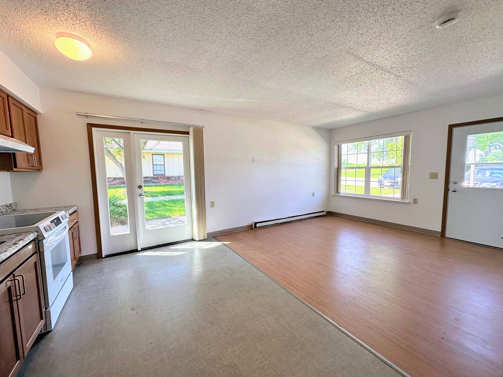 an empty kitchen and living room with a door to the yard