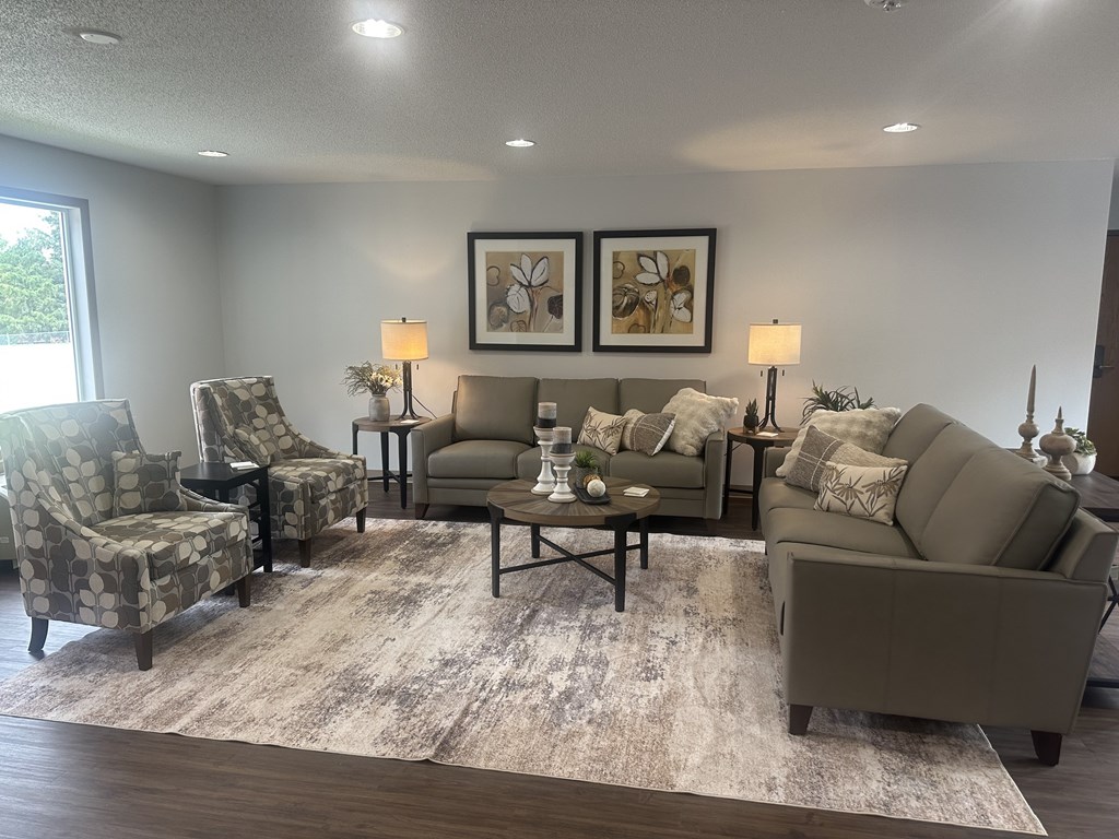 A living room with a grey sofa, two chairs, and a coffee table.