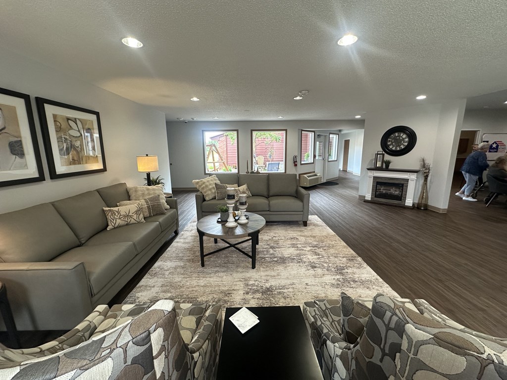 A living room with a grey couch, a coffee table, and a fireplace.