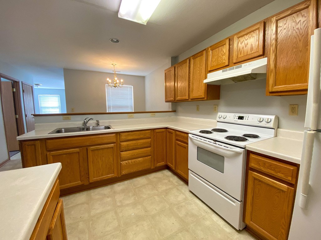 a kitchen with white appliances and wooden cabinets