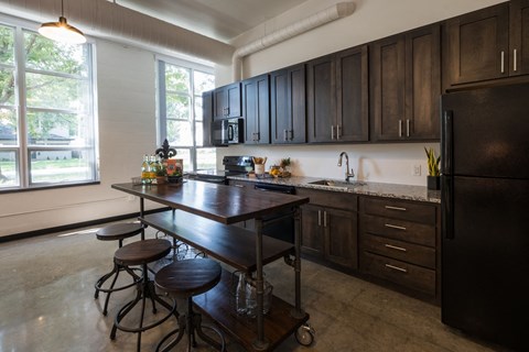 A kitchen with a table and chairs in front of a window.