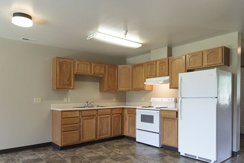 A kitchen with wooden cabinets and a white refrigerator.