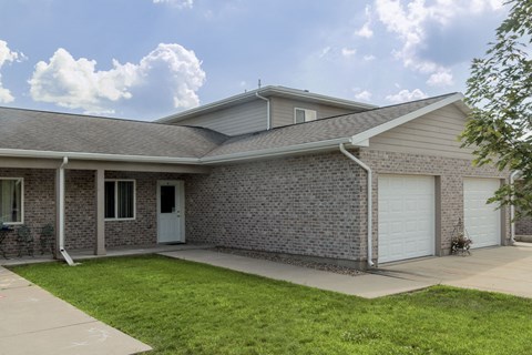 A house with a grey roof and a white garage door.