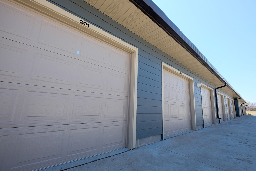 A row of garage doors are closed and numbered 201.