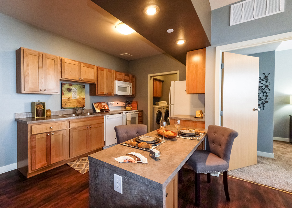 A kitchen with wooden cabinets and a dining table with chairs.
