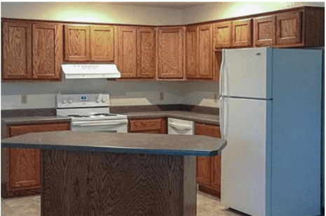 a kitchen with an island and a white refrigerator