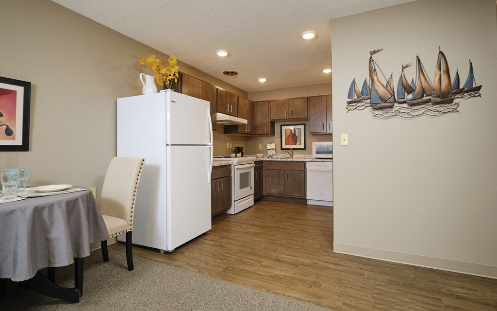 a kitchen with a white refrigerator freezer next to a white stove top oven