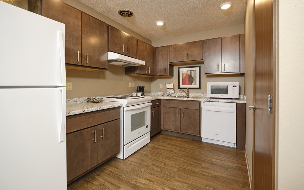 a kitchen with brown cabinets and white appliances