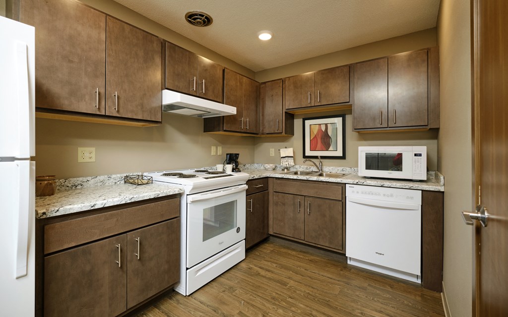 a kitchen with white appliances and brown cabinets
