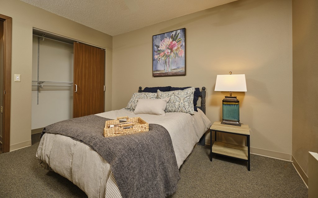 a bedroom with a bed and a table with a lamp