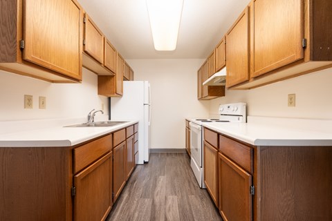 A kitchen with wooden cabinets and white appliances.