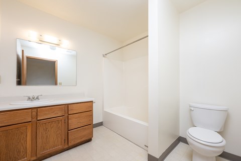 A white toilet sits next to a white sink in a bathroom.