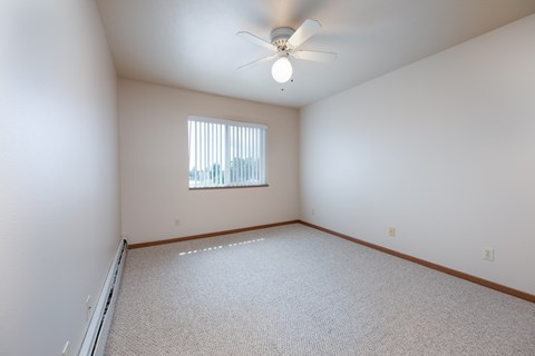 A room with a ceiling fan and a window.