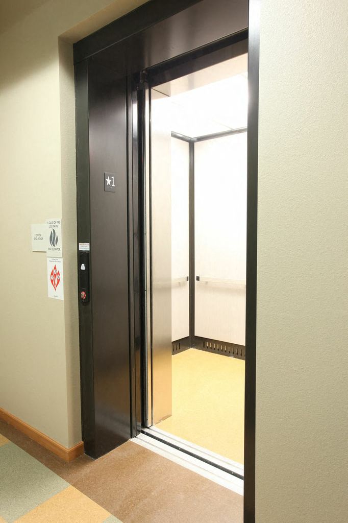 An elevator with the doors open to see the inside of the elevator
