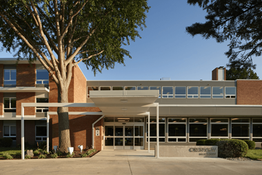 a large brick building with a large tree in front of it