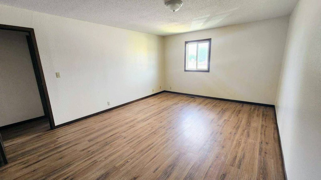 an empty living room with white walls and wood floors