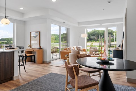 a living room and dining room with a table and chairs