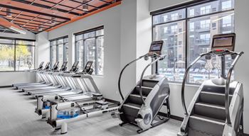 a gym with cardio equipment and a row of exercise machines at Expo, Minneapolis, MN 55414