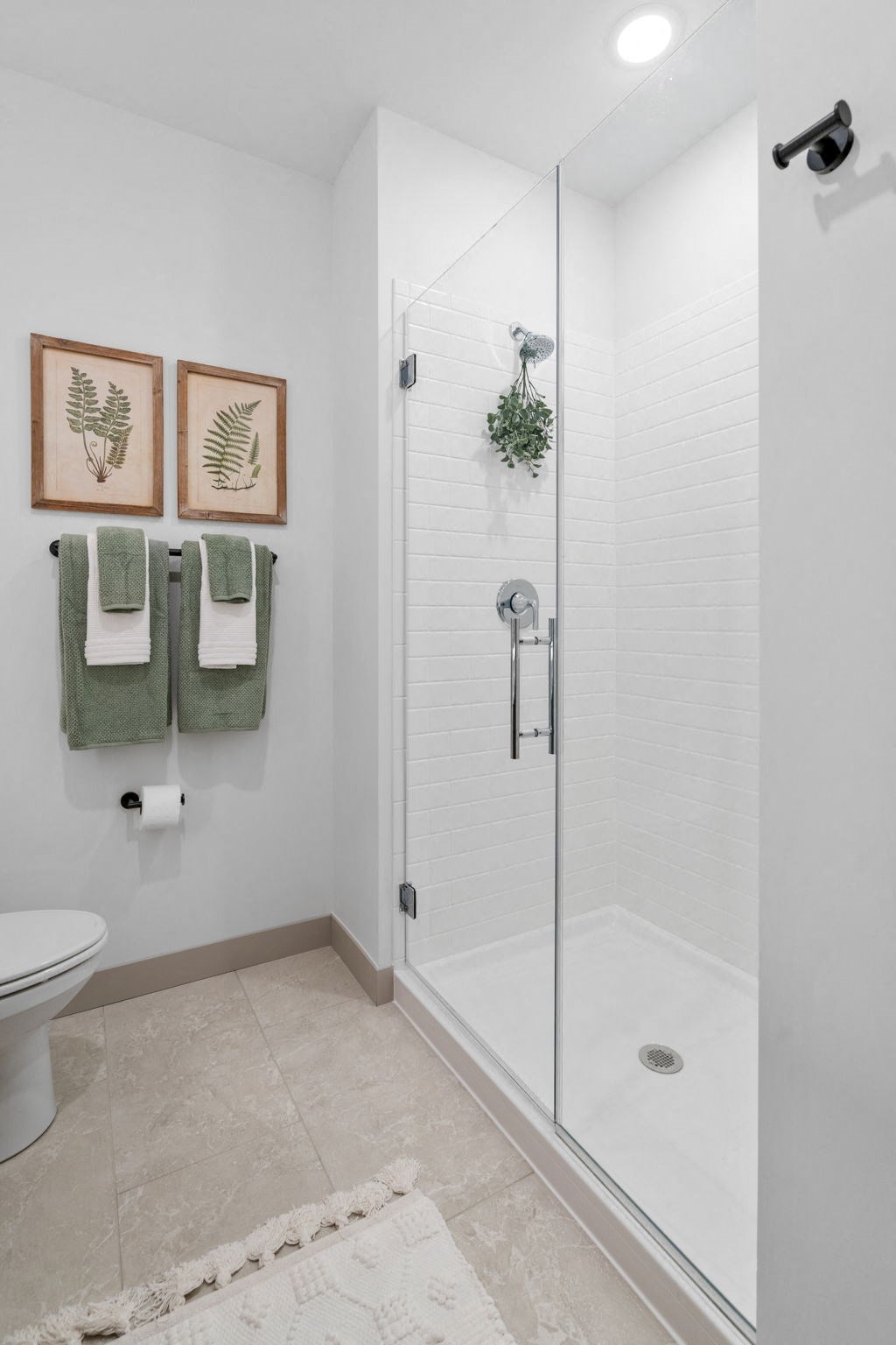 a white bathroom with a shower and a toilet at The Mera, St Louis Park, MN 55426