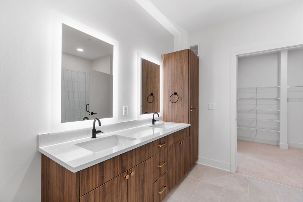 A bathroom with a double sink vanity and a large mirror.