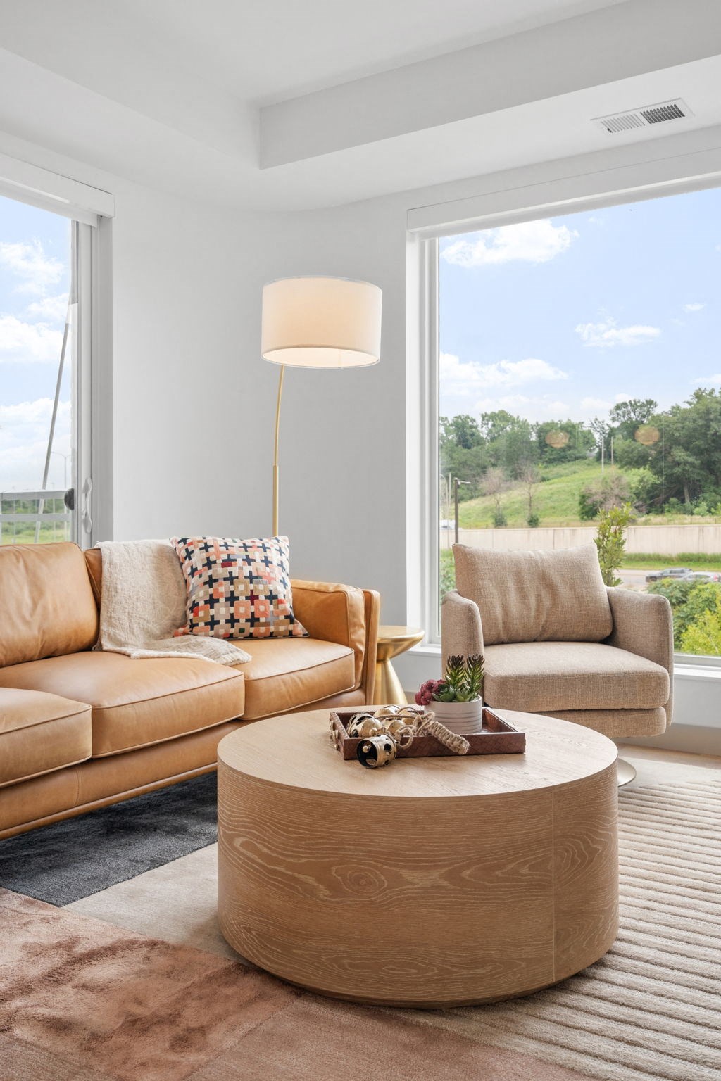 a living room with couches and a coffee table and a large window at The Mera, Minnesota 55426