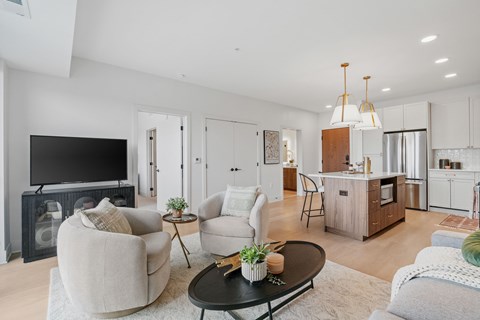 A modern living room with a black coffee table and a large flat screen TV.
