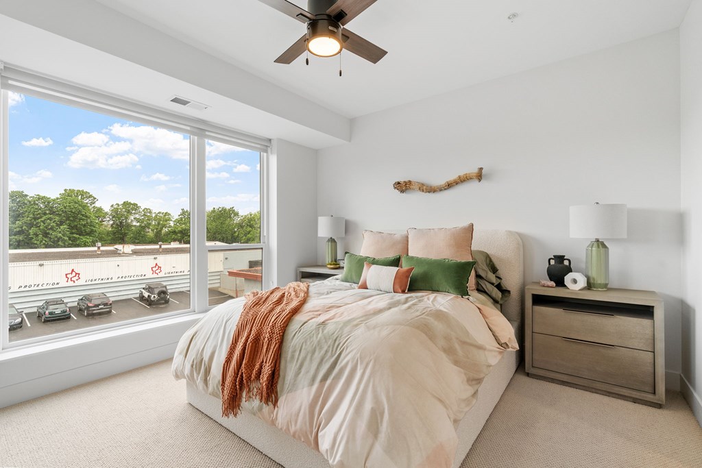 A bedroom with a queen-sized bed in a one-bedroom, one-bathroom apartment home at Lilia in Lilydale, MN 55118