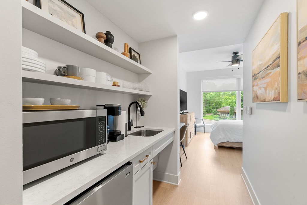 The kitchen featuring a mini fridge, microwave, sink, coffeemaker, toaster, and dishes in the Guest Suite, a reservable community amenity at Lilia in Lilydale, MN 55118