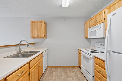 A kitchen with wooden cabinets and white appliances.