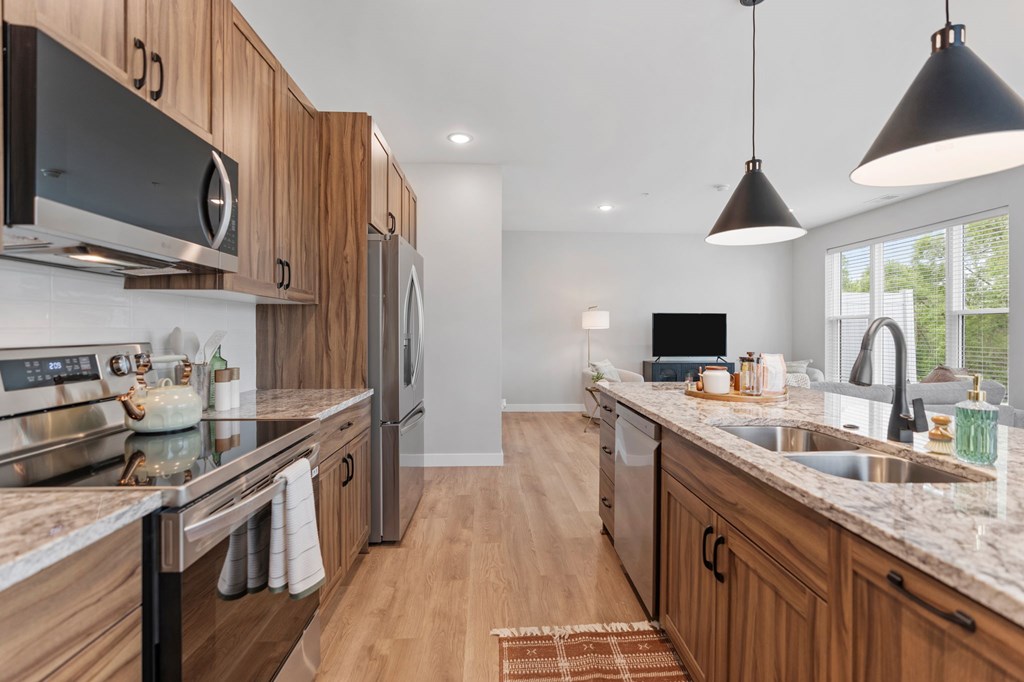A modern kitchen with wooden cabinets and granite countertops. at Townhomes at Preserve, Rogers, MN, 55374
