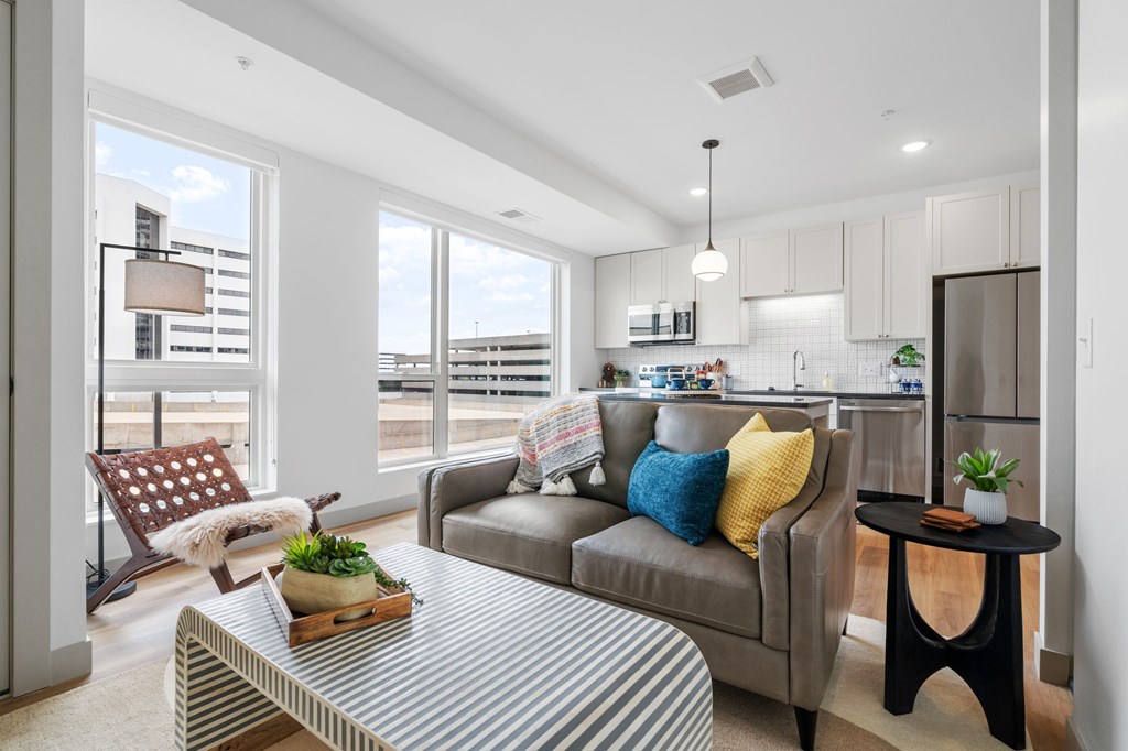 A modern living room with a grey couch and a striped coffee table. at The Mera, St Louis Park, MN, 55426