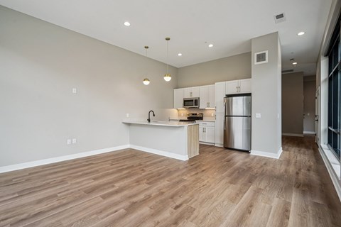 A kitchen with a refrigerator, microwave, and oven.