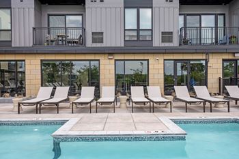 Outdoor pooldeck and spa with lounge chairs and cabanas at Lilia Apartments in Lilydale, MN 55118