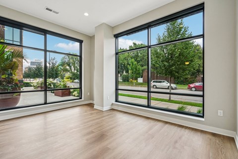 A room with a view of a street and cars outside.
