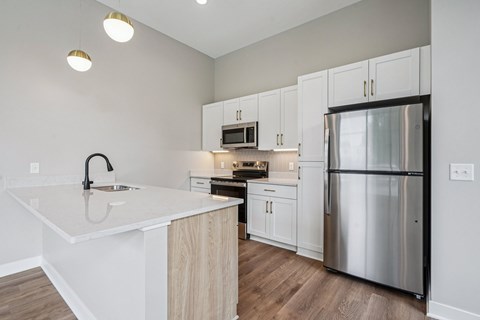 A modern kitchen with a stainless steel refrigerator and white countertops.