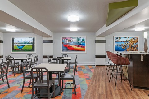 a dining room with tables and chairs and paintings on the wall at Axon Green, Minneapolis, MN, 55416