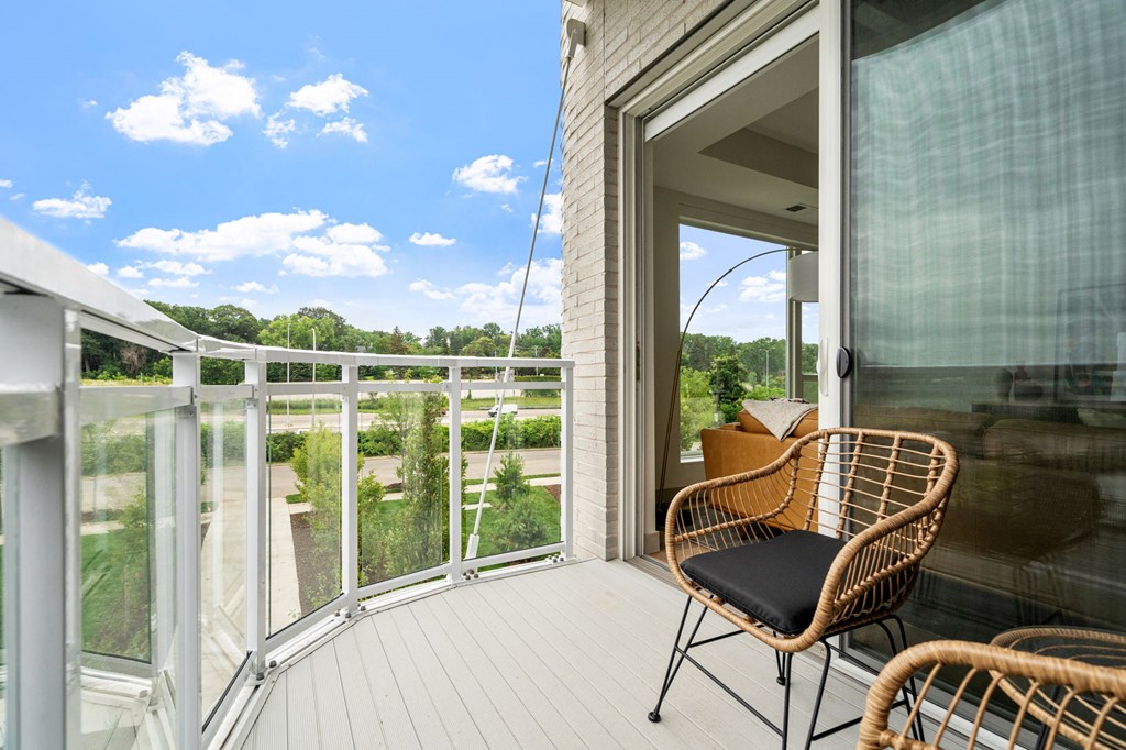 a balcony with a wicker chair and a view of the outdoors at The Mera, St Louis Park