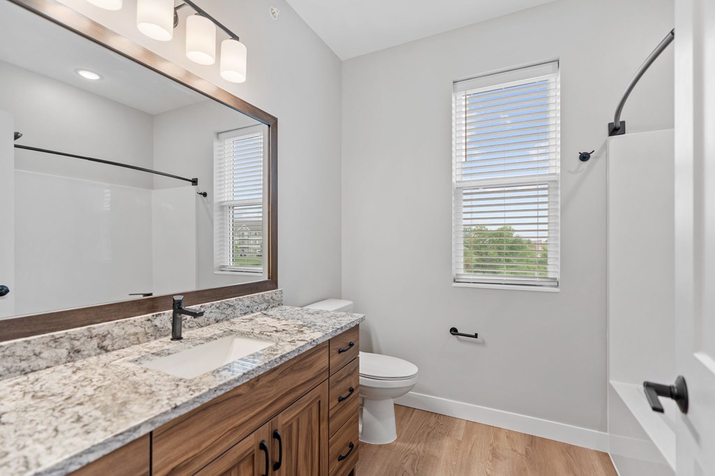 A bathroom with a marble countertop and a large mirror. at Townhomes at Preserve, Rogers, MN, 55374