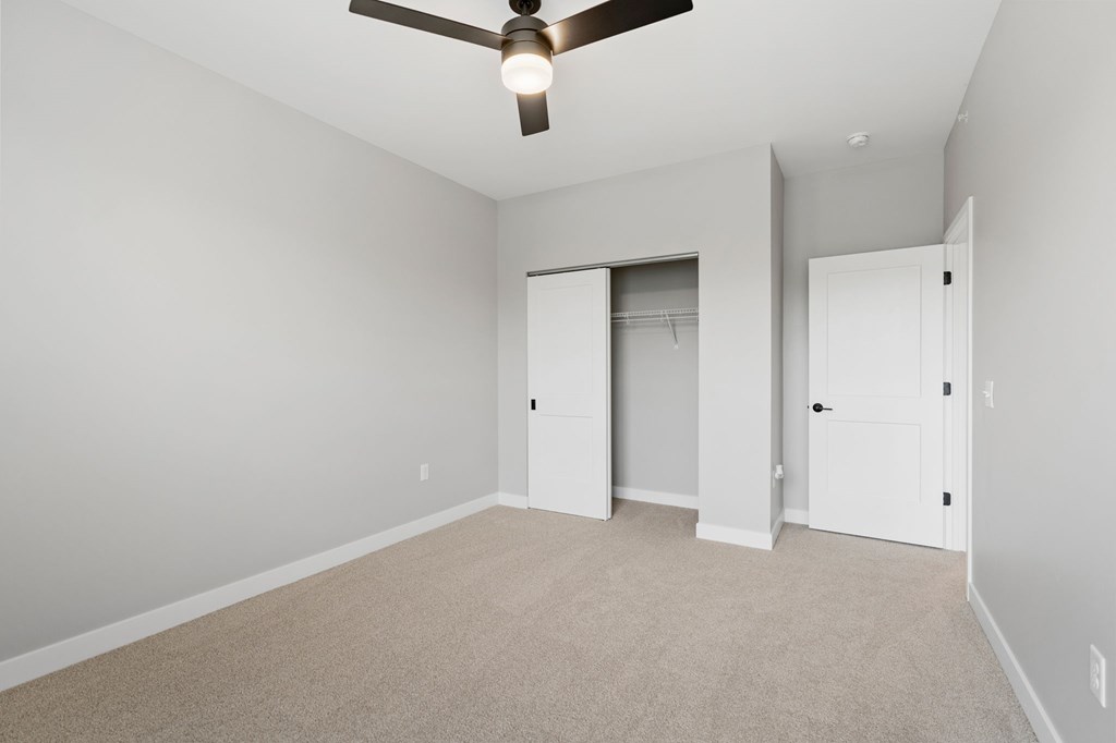 A room with a ceiling fan and carpeted floor. at Townhomes at Preserve, Rogers, 55374