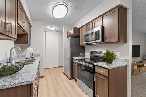 A kitchen with brown cabinets and a granite countertop.