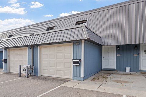 A building with a blue garage door and a white door.