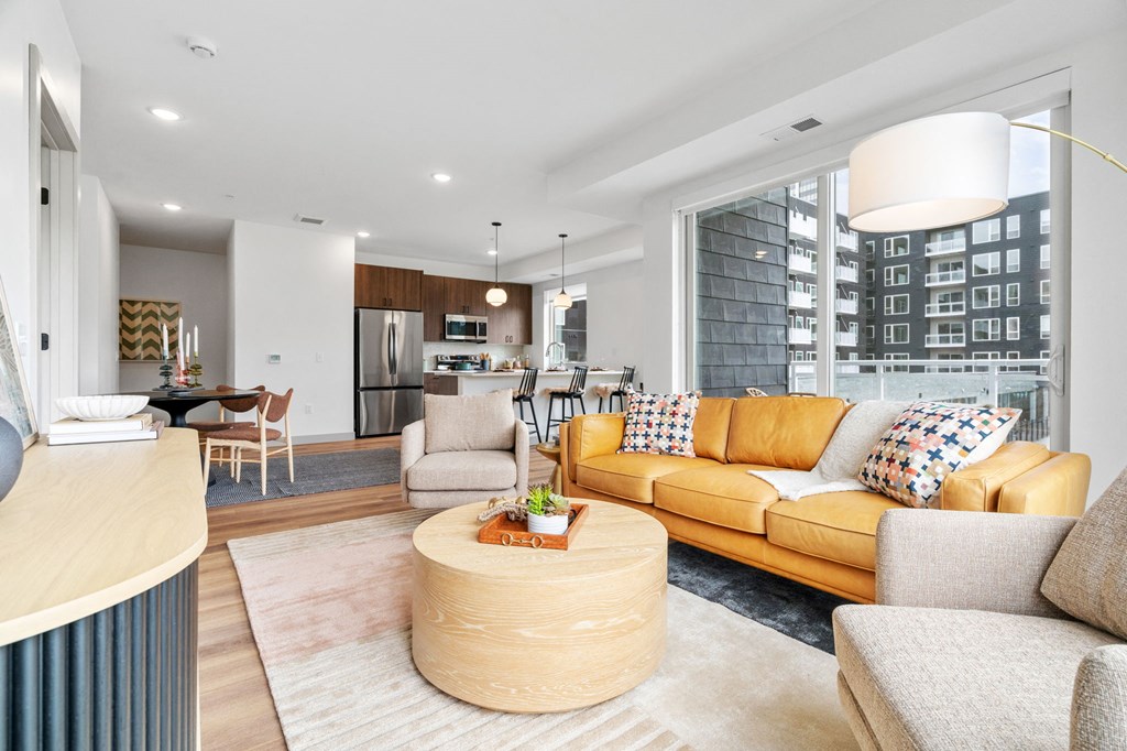 A modern living room with a yellow sofa and a wooden coffee table. at The Mera, St Louis Park, MN