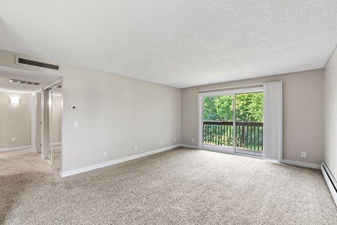 Living room and private patio in a renovated apartment home at Oakwood Apartments in Plymouth, MN  55447