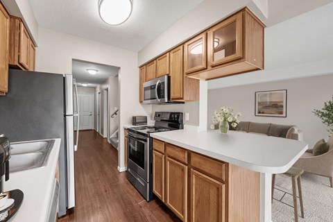 A kitchen with wooden cabinets and a white counter.