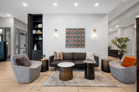 A modern living room with a grey sofa, a brown armchair, and a coffee table.