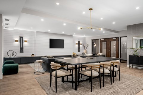 A modern dining room with a large table and chairs.