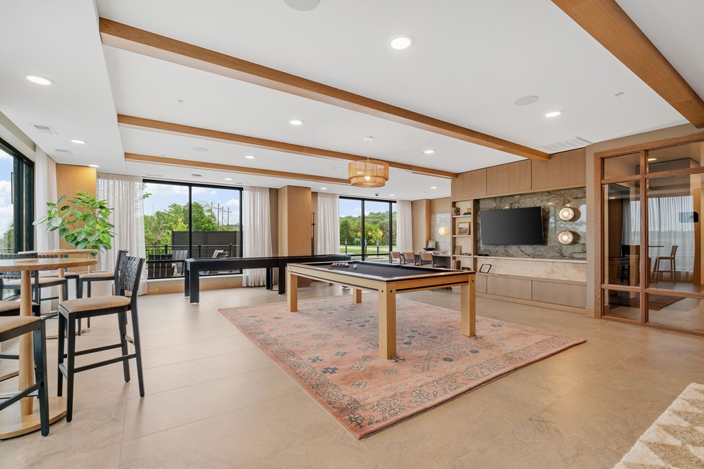 The billiards table and shuffleboard game in the Game Lounge, a reservable community room at Lilia in Lilydale, MN 55118