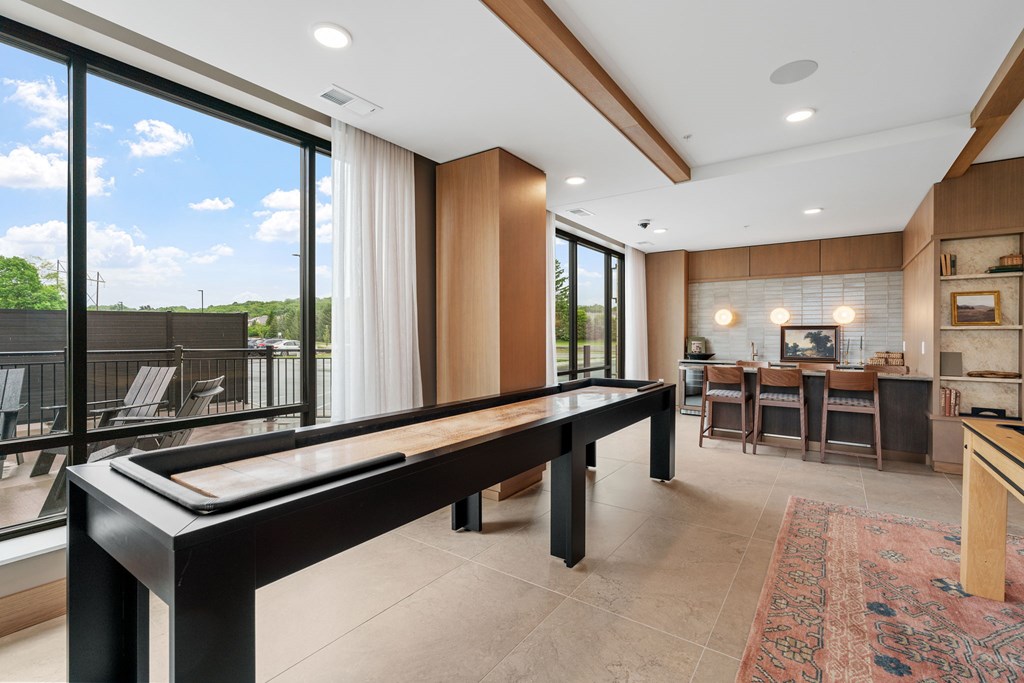The billiards table and shuffleboard game in the Game Lounge, a reservable community room at Lilia in Lilydale, MN 55118
